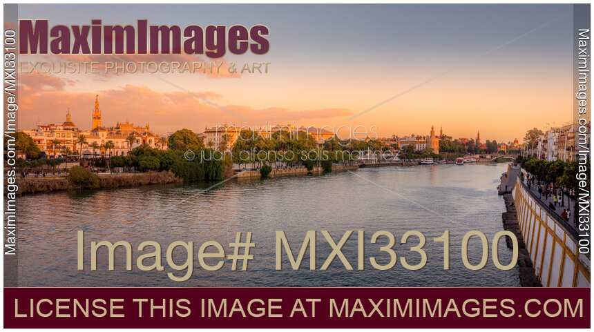 River Guadalquivir in Seville Spain and the Giralda Cathedral in panoramic sunset scenery
