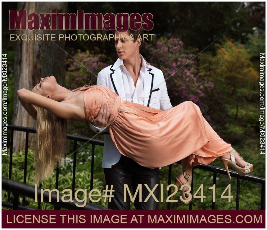 Romantic couple, handsome man walking with fainting beautiful lady in his arms