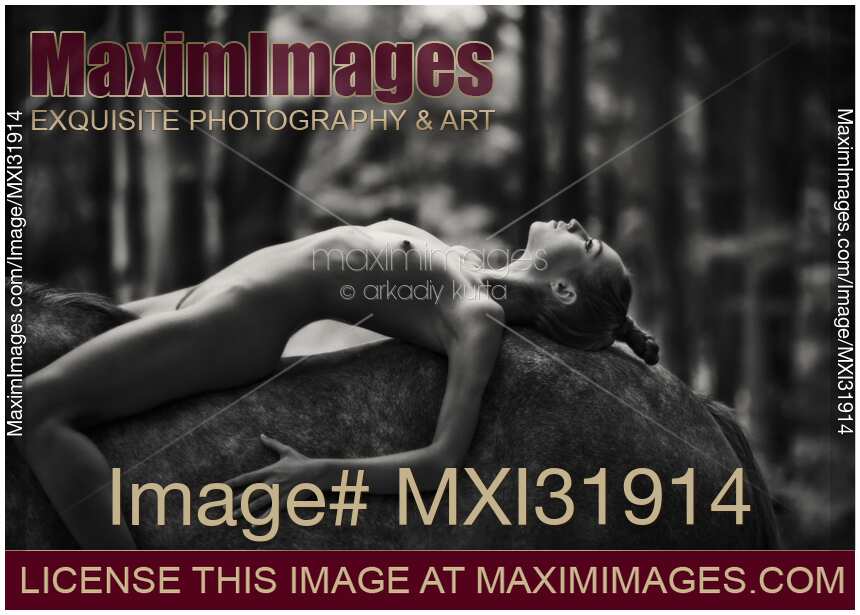 Romantic fine art black and white nude photograph of a young woman lying on the horse