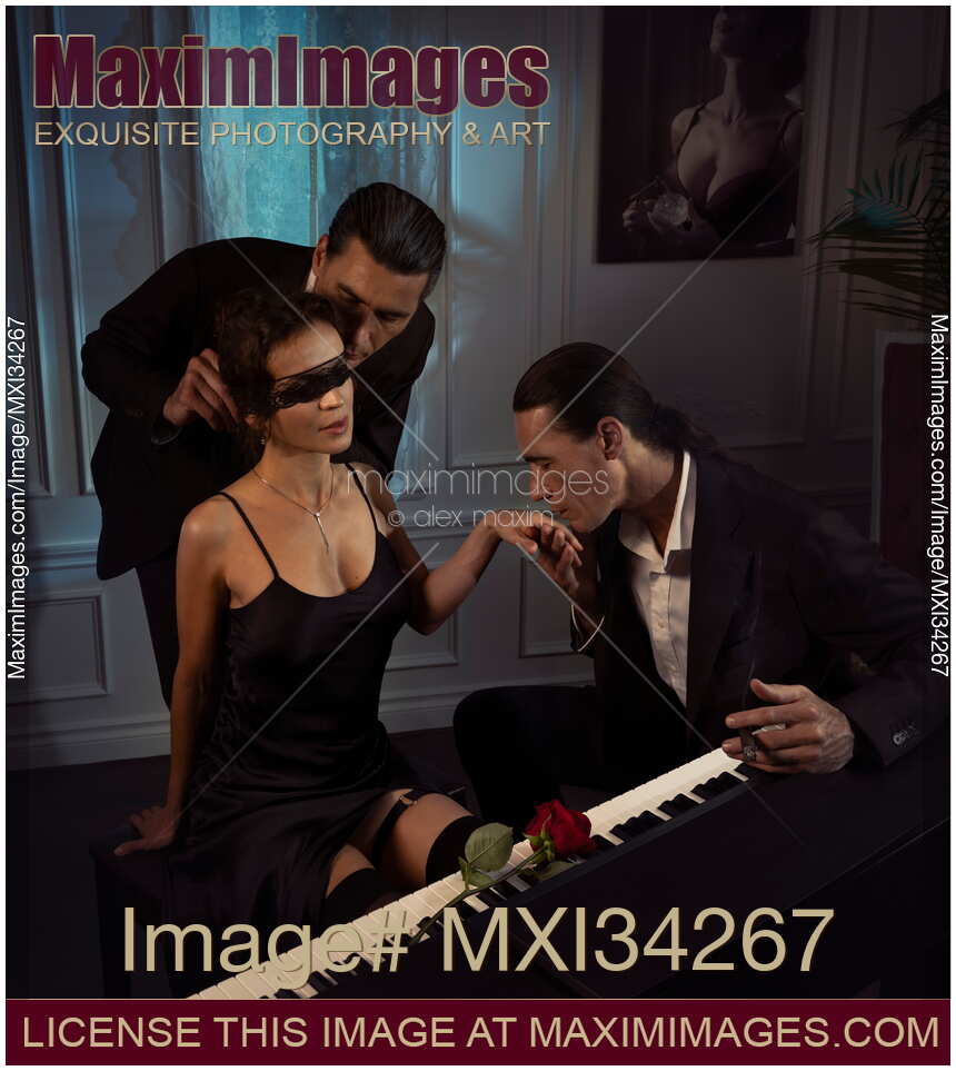 Romantic Menage a trois of two men seducing a beautiful sexy woman sitting at a piano