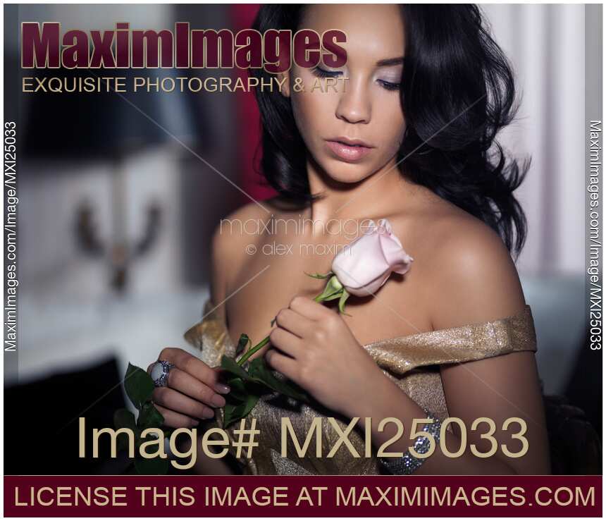 Romantic portrait of young woman with rose in hands