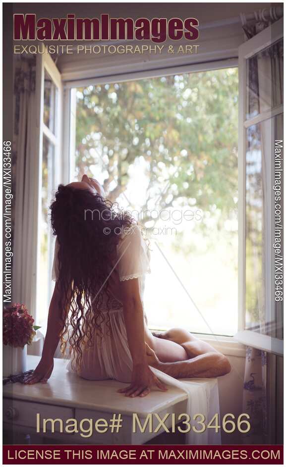 Romantic sensual couple making love in front of an open window in countryside