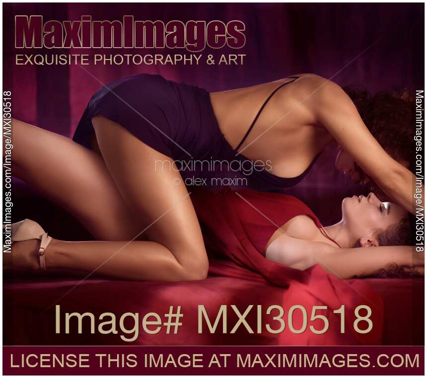 Romantic sensual lesbian couple making love on a bed Two beautiful sexy women in dresses kissing