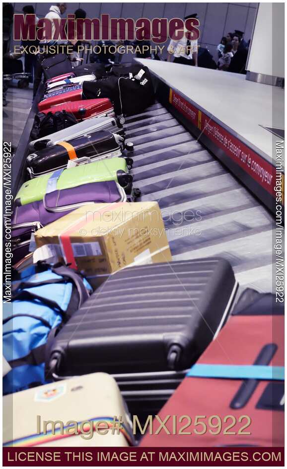 Row of suitcases on airport baggage claim conveyor