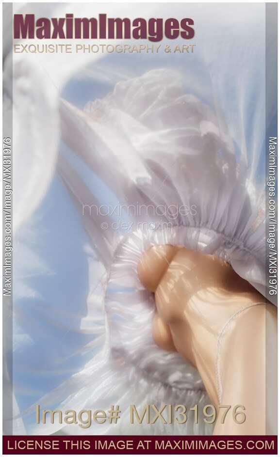 Sensual abstract of woman half nude body under a flying sheer summer dress