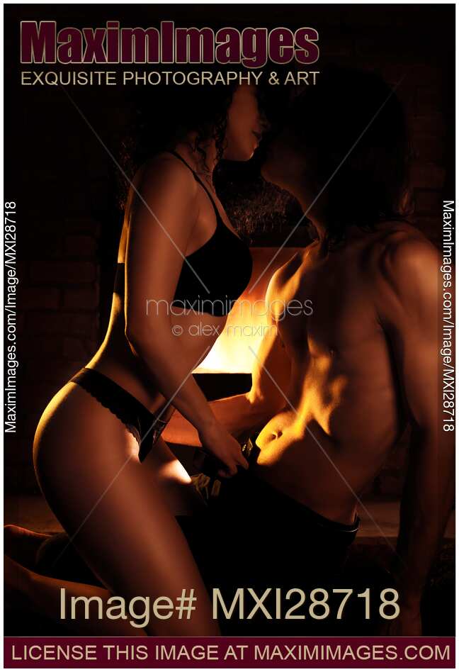 Sensual artistic photo of couple making love in front of fireplace