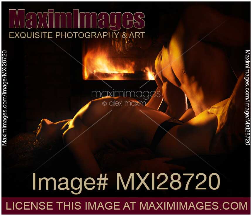 Sensual artistic photo of sexy couple making love in front of fireplace