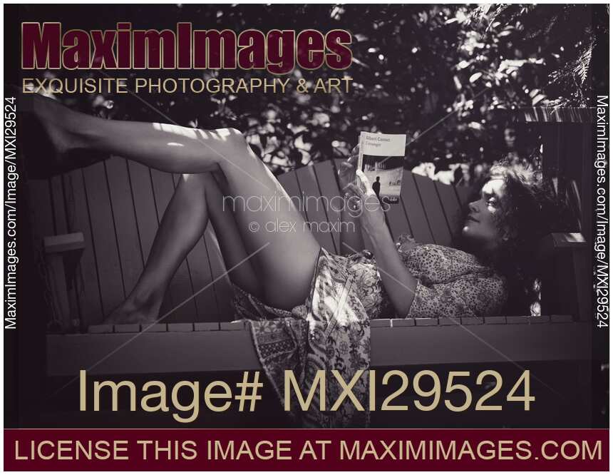 Sensual black and white portrait of a woman reading book on garden bench