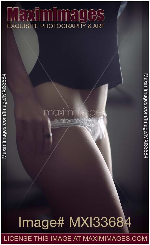 Sensual body parts closeup of a sexy woman undressing taking off her white lace underwear