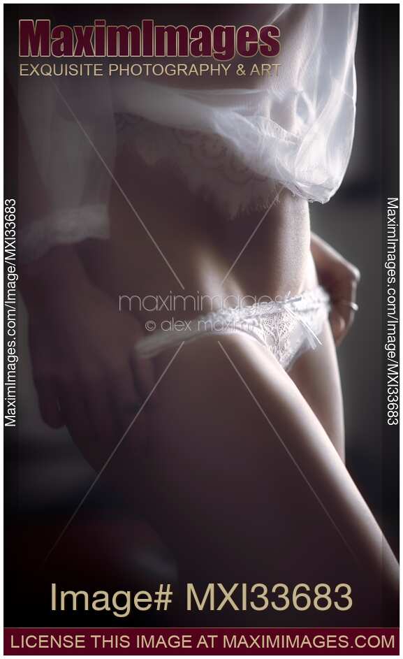 Sensual boudoir closeup of a sexy woman in underwear undressing taking off her white lace panties