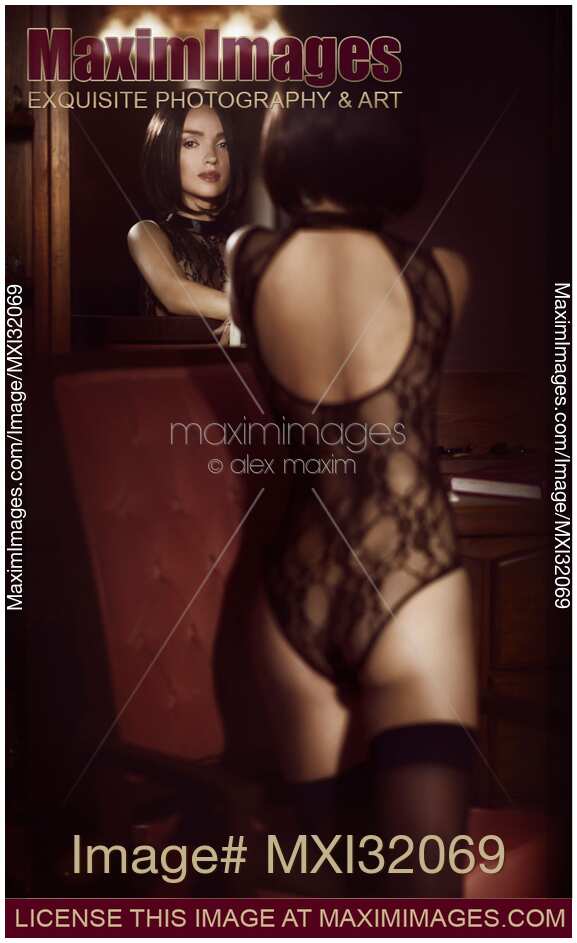 Sensual boudoir portrait of a sexy woman in lace underwear with her face reflecting in the vanity mirror