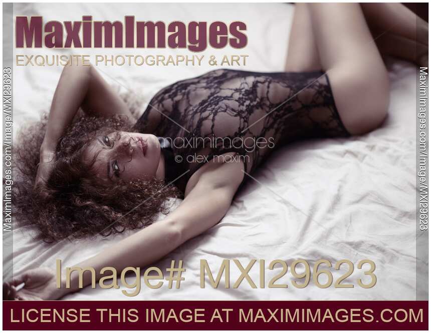 Sensual boudoir portrait of a sexy woman lying on bed in lacy underwear