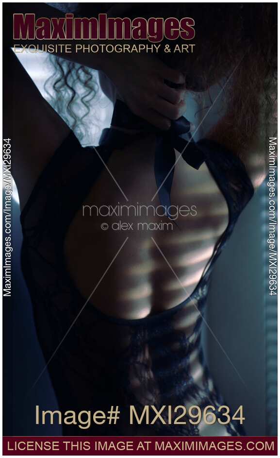 Sensual boudoir portrait of a woman undoing underwear on her back