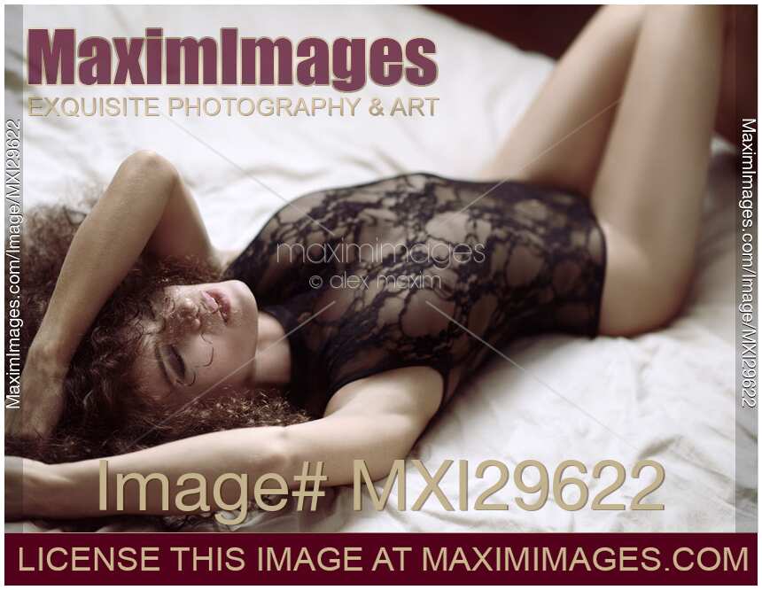 Sensual boudoir portrait of beautiful sexy woman lying on bed in underwear