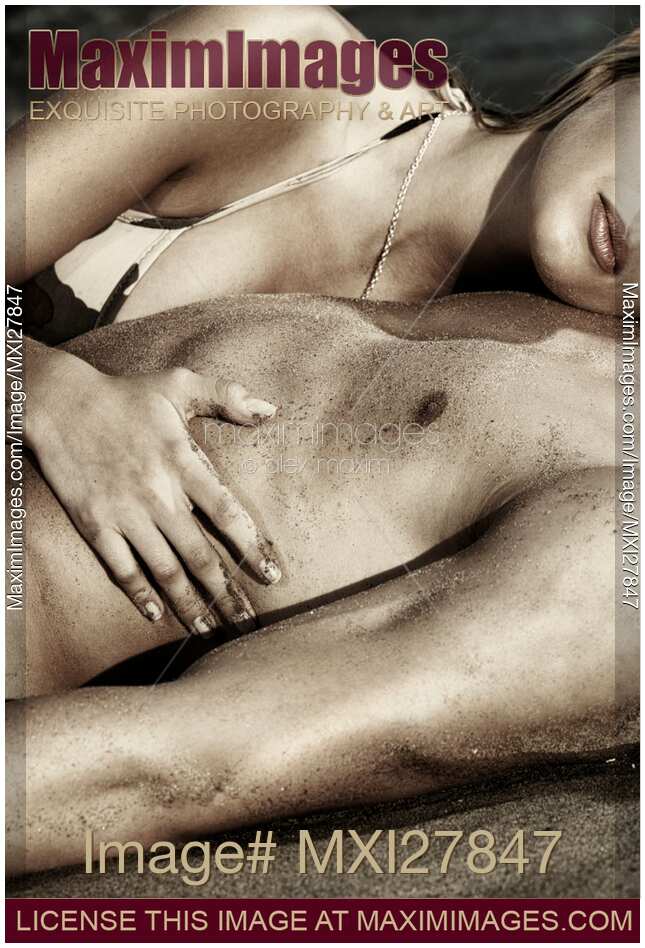 Sensual closeup of a couple lying together on sand
