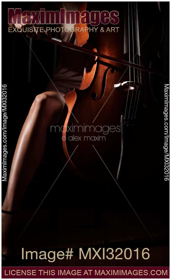 Sensual closeup of a woman hand with a bow passionately playing cello in a sexy small dress with bare legs