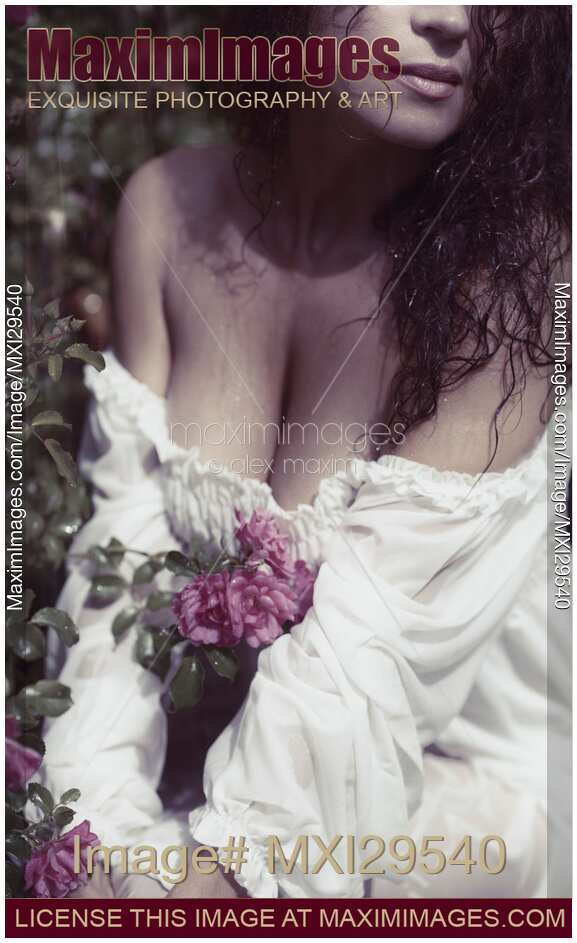 Sensual closeup of a woman with wet hair in rose garden in rain