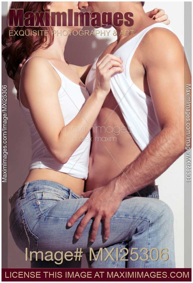 Sensual closeup of a young woman taking of man's white tank top