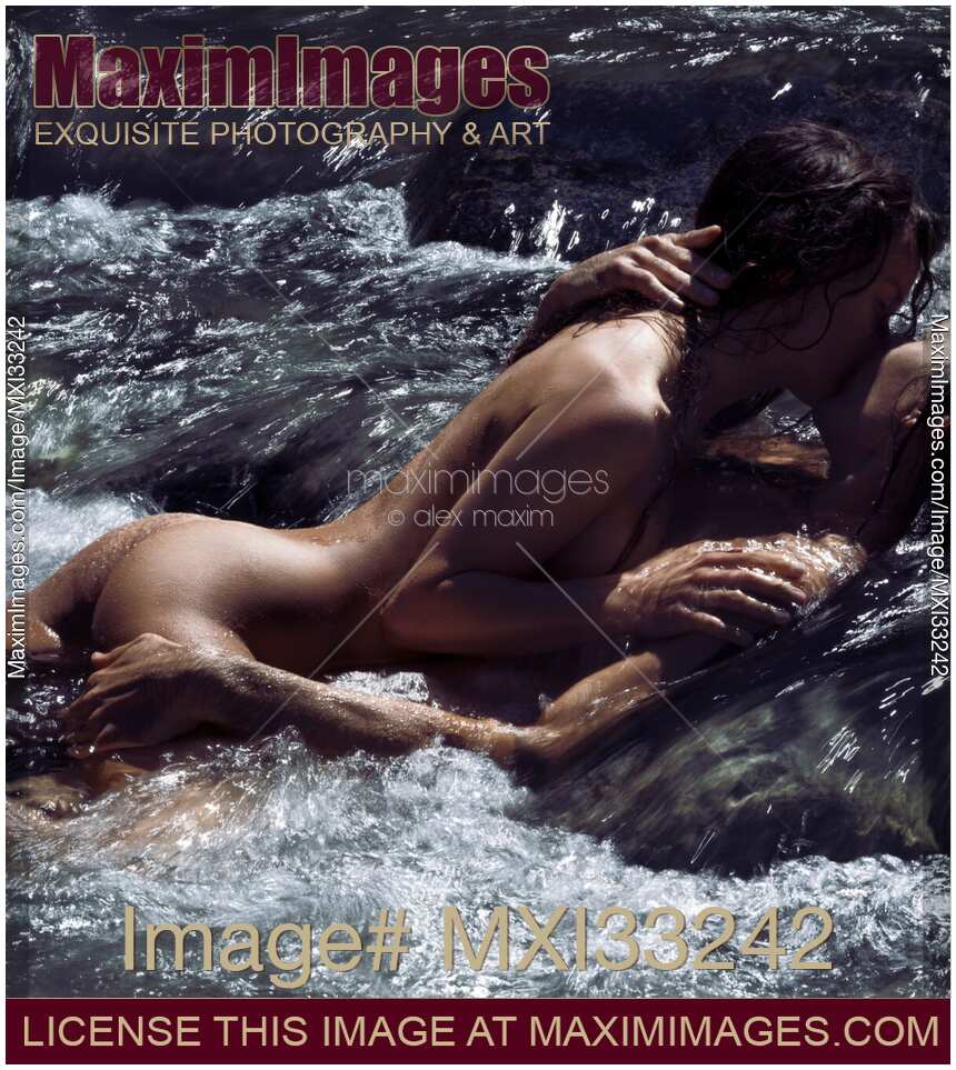 Sensual couple in an embrace lying kissing naked in turbulent water of a mountain river