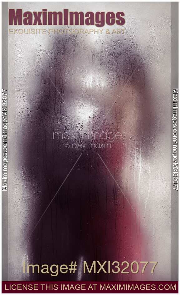 Sensual couple kissing standing behind wet glass in an embrace Dreamy abstract fine art concept