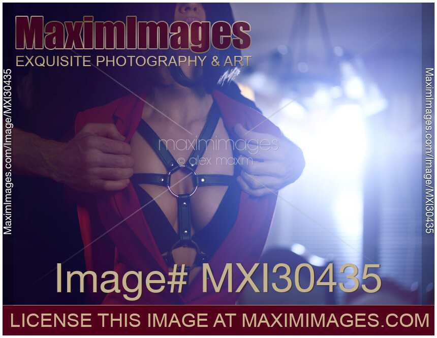 Sensual couple Man hands undressing sexy woman revealing leather bondage harness under her clothes