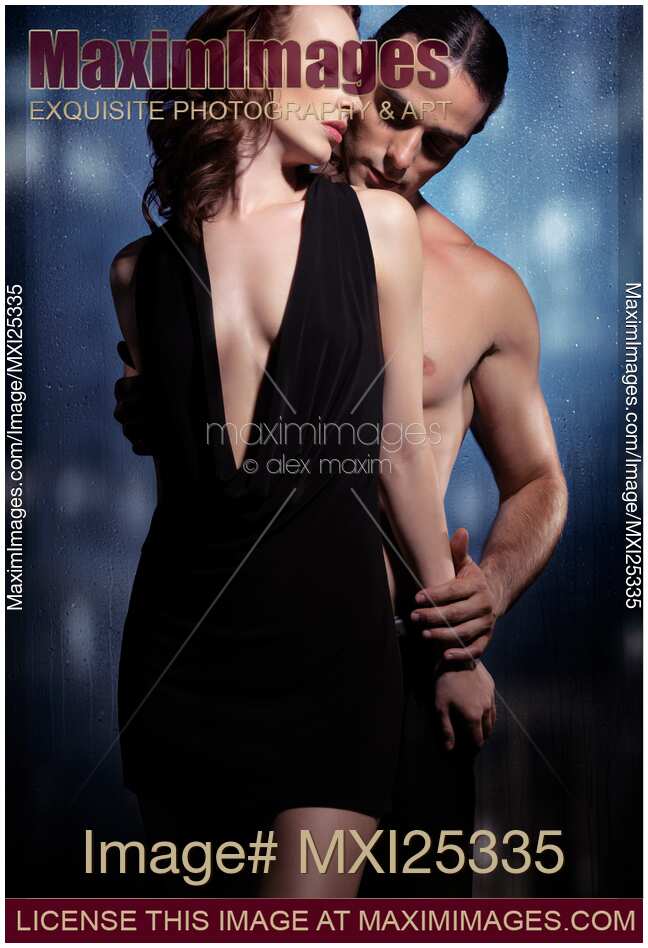 Sensual couple portrait of man and woman embracing at a window