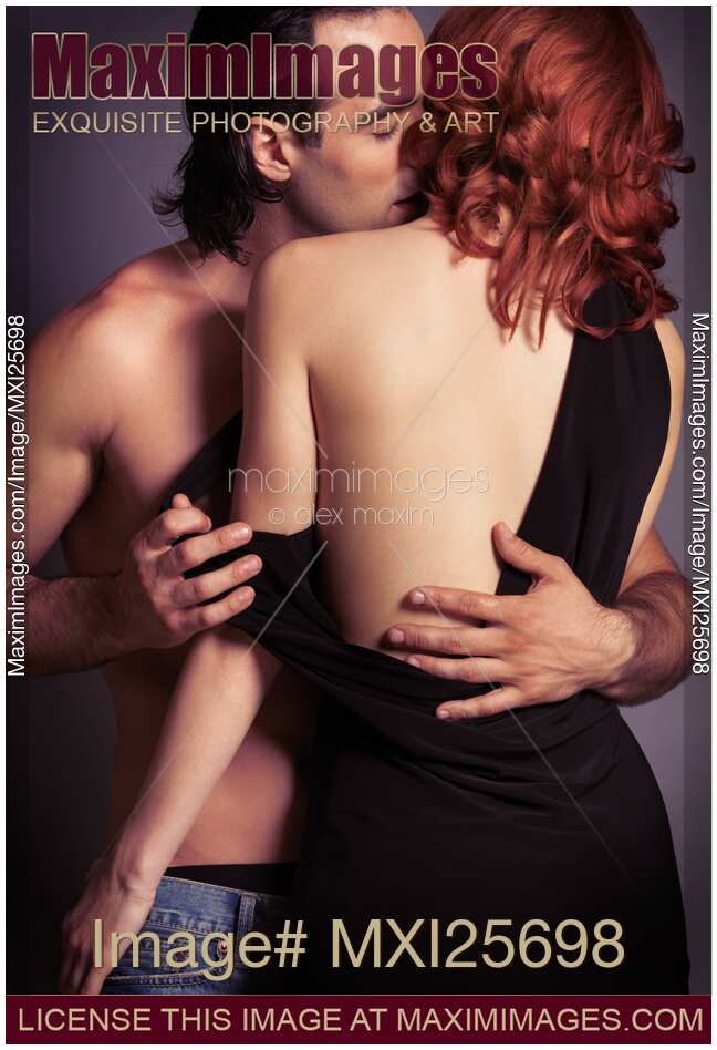 Sensual couple portrait of man kissing redhead woman