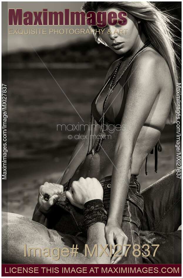 Sensual dramatic black and white portrait of a sexy couple at a sandy beach