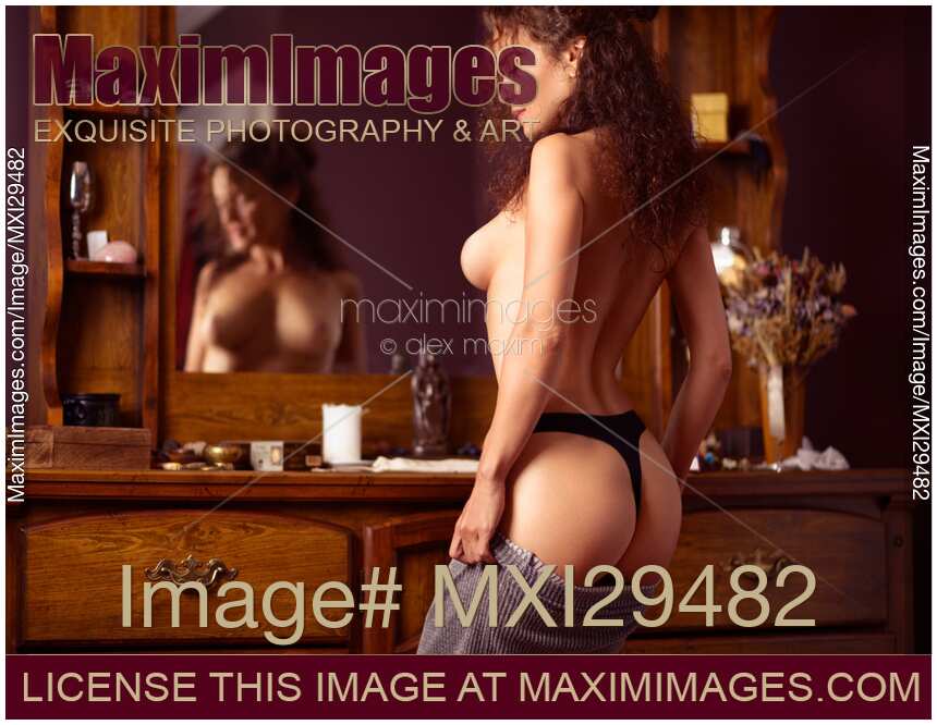 Sensual erotic portrait of a sexy topless woman in underwear dressing up