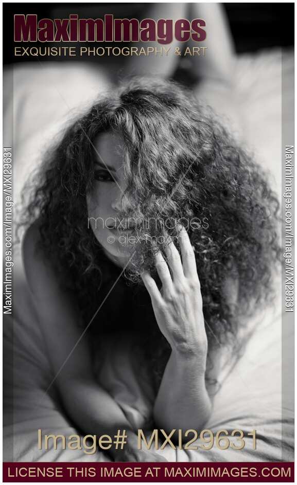 Sensual expressive portrait of a woman lying on a bed Black and white