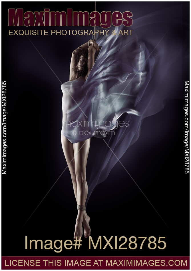 Sensual nude photo of a Woman suspended in mid-air on bondage rope with flowing cloth around her body