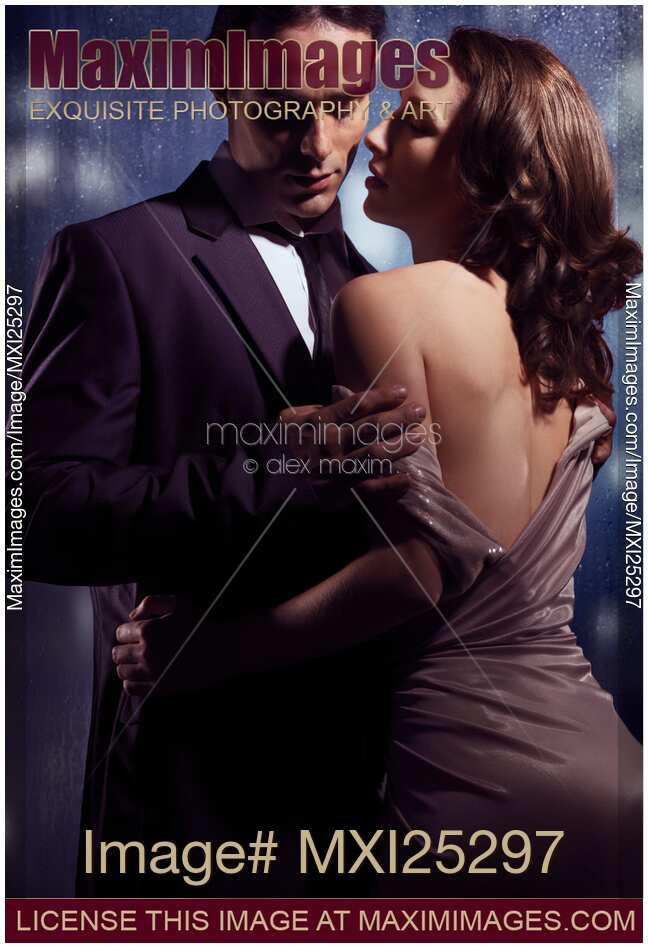 Sensual photo of couple standing near window on rainy night