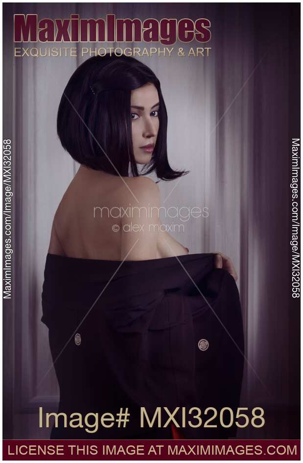 Sensual portrait of a beautiful asian woman with short black hair and expressive look taking off kimono