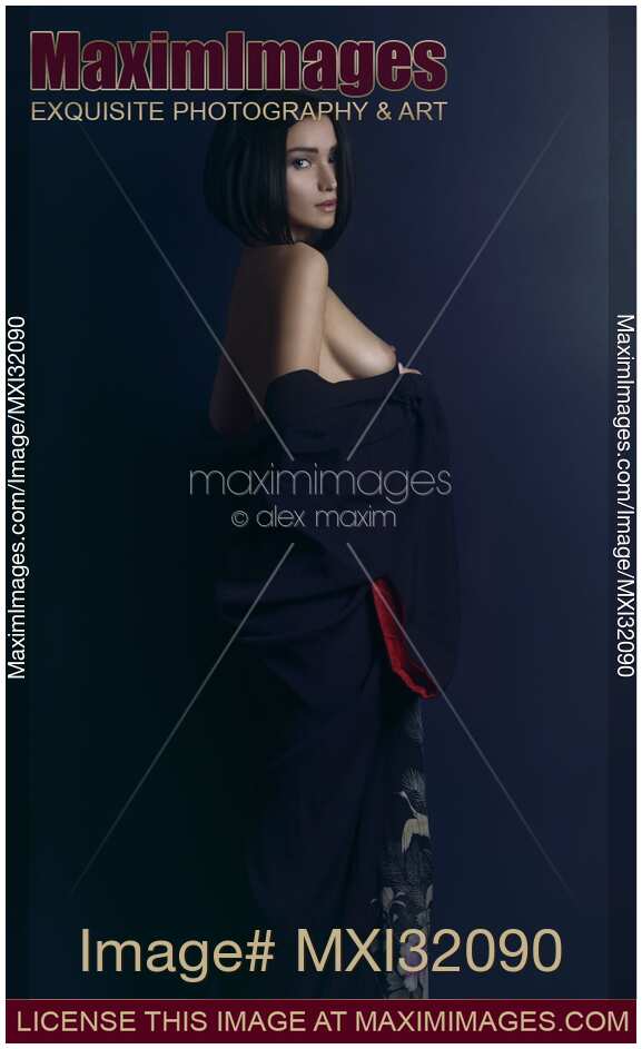 Sensual portrait of a beautiful woman with short black hair and expressive look baring her breasts