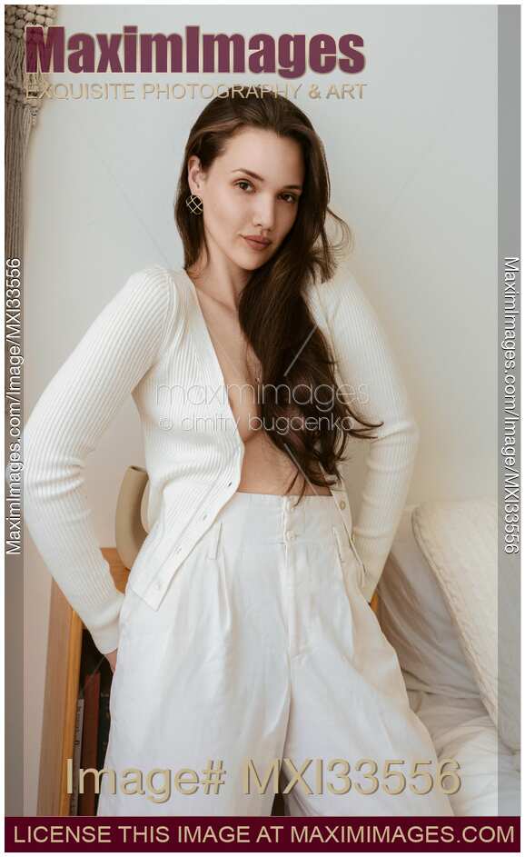 Sensual portrait of a sexy woman with long brown hair in unbuttoned white cardigan