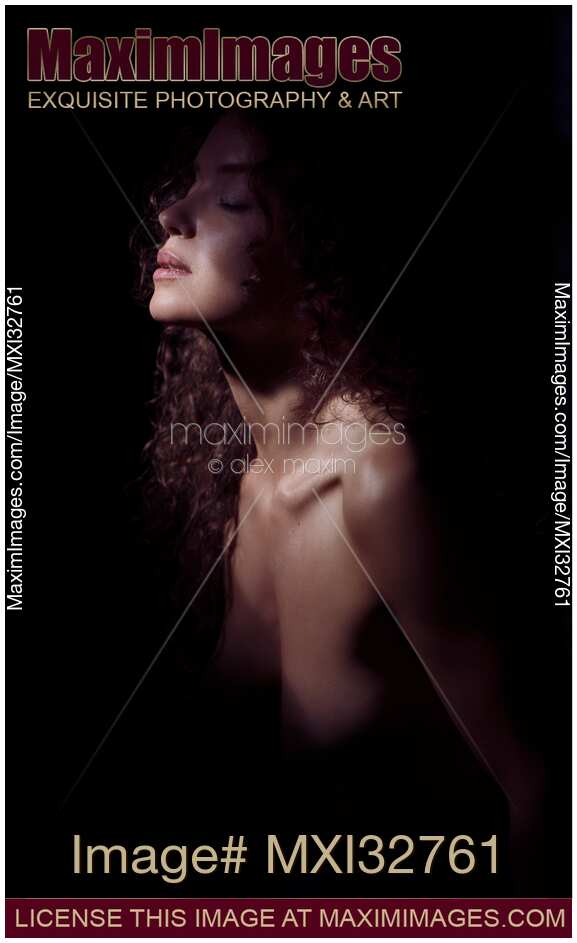Sensual portrait of a woman closeup of face and neck and bare chest in dramatic light