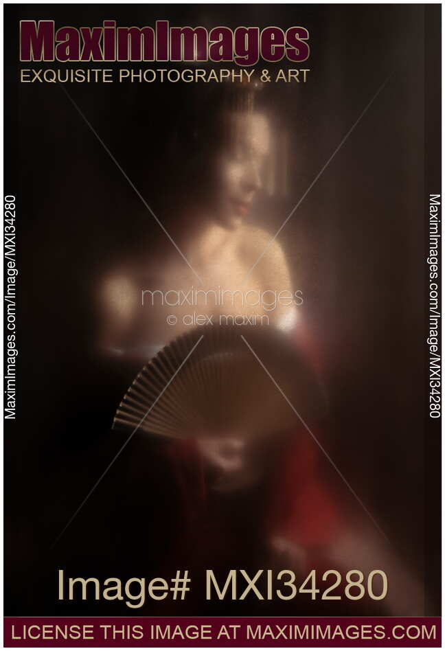 Sensual portrait of beautiful Japanese geisha or courtesan with bared shoulders and a hand fan behind glass
