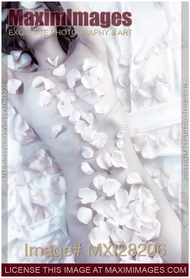 Sensual portrait of beautiful nude asian woman covered with rose petals