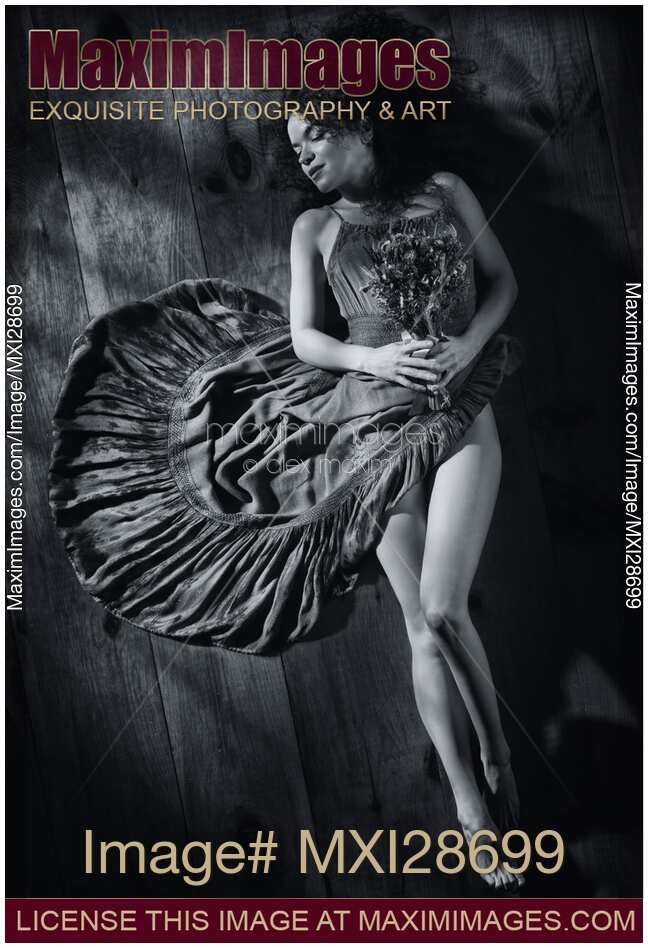 Sensual portrait of woman in dress with bare legs lying on the floor Black and white
