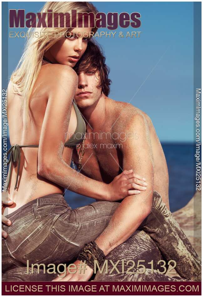 Sensual Portrait of Young Couple Sitting Together on the Beach