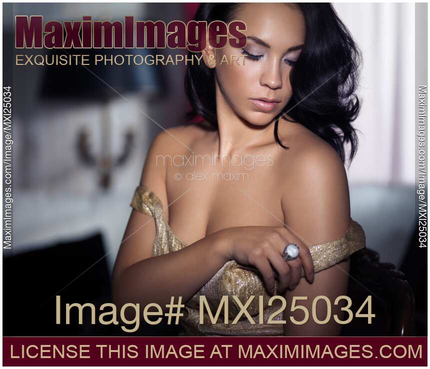 Sensual portrait of young woman undressing in bedroom