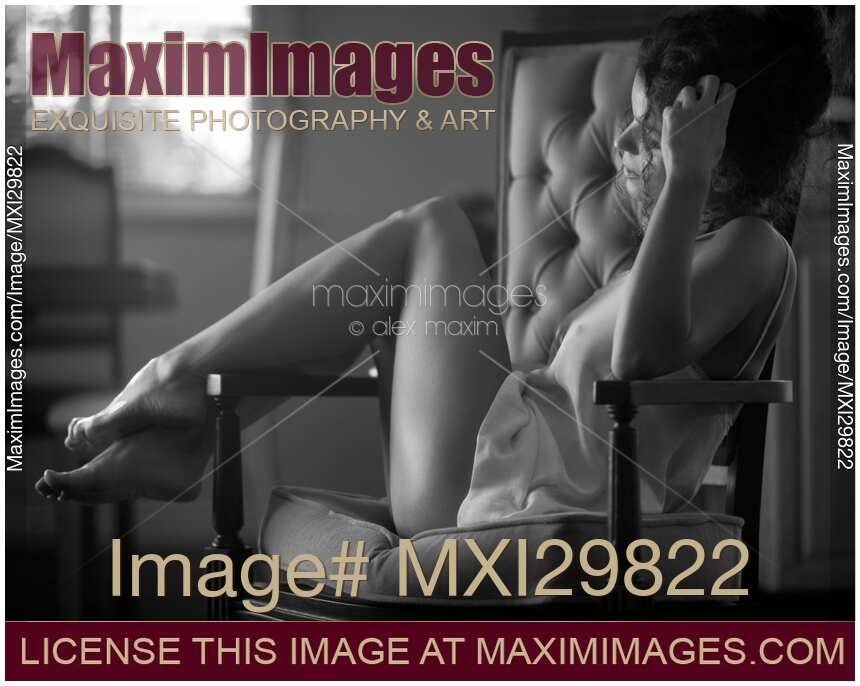 Sensual romantic black and white portrait of young woman in underwear sitting in armchair