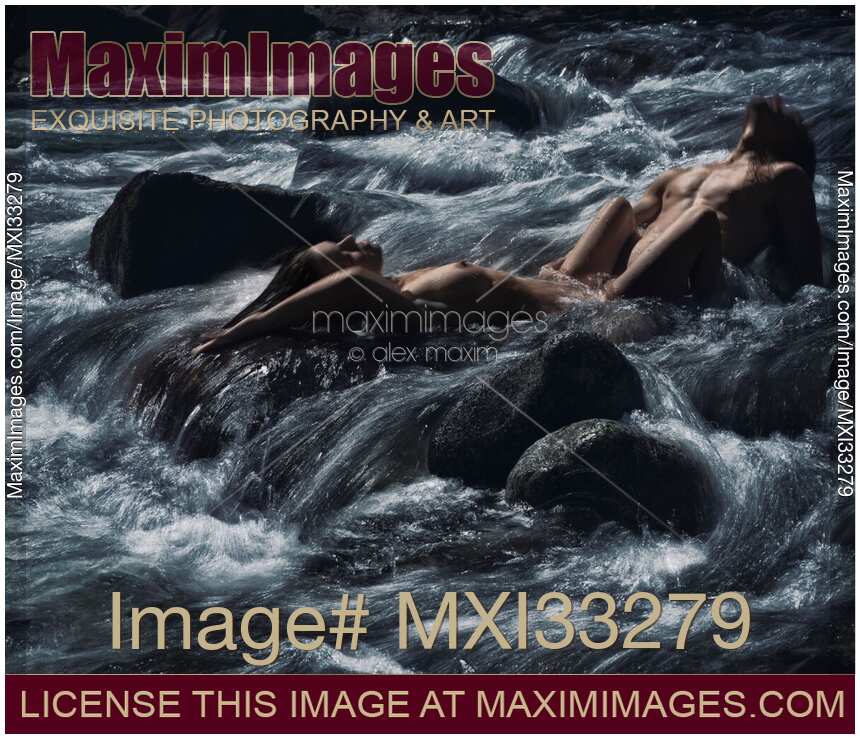 Sensual romantic nude couple making love in wild water of a mountain river in dramatic nature scenery