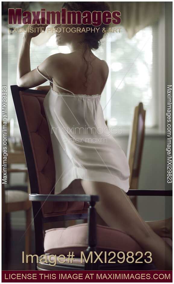 Sensual romantic portrait of sexy young woman in underwear leaning on armchair