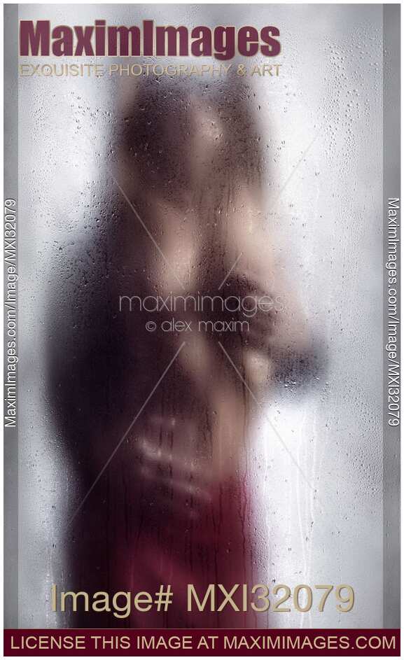Sexy couple behind wet glass Man hands caressing beautiful half naked woman body