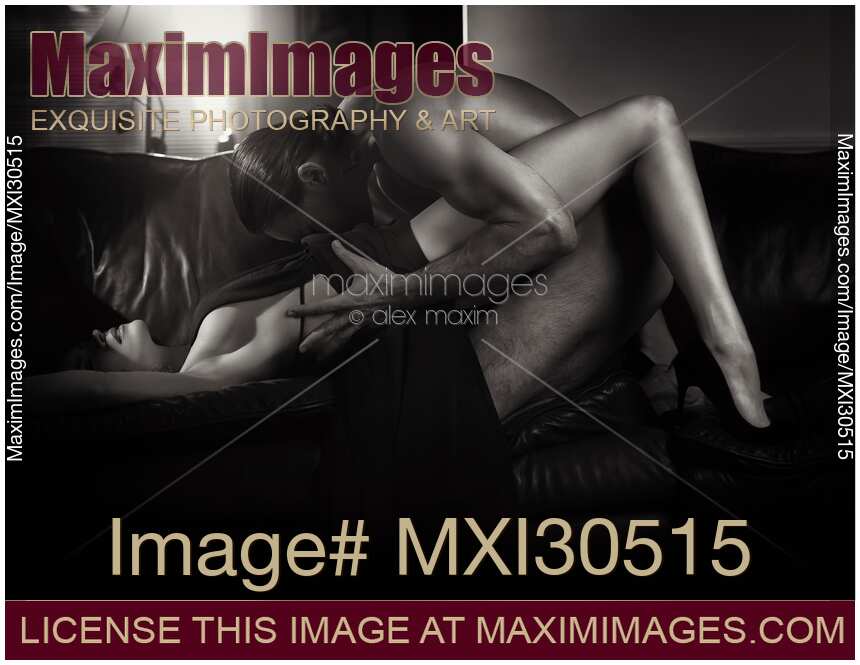 Sexy couple making love on a sofa Woman in a long dress and a naked man caressing her body Black and white