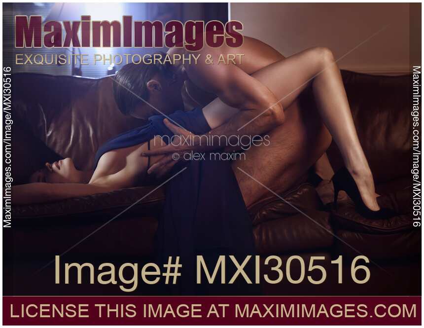 Sexy couple making love on a sofa Woman in a long dress and a naked man caressing her body