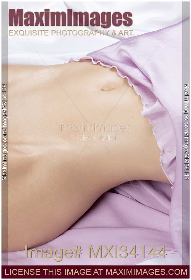 Sexy half-naked woman body midsection with sensual curves and smooth skin on white satin bed