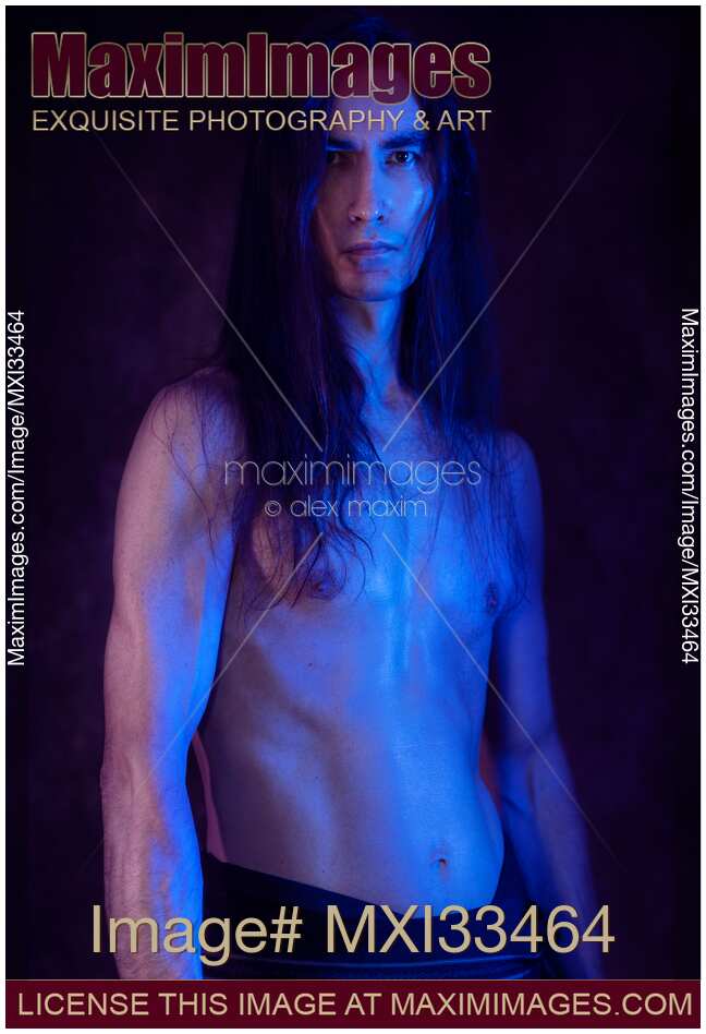 Sexy Japanese warrior with bare sweaty torso artistic portrait in dramatic blue and purple light