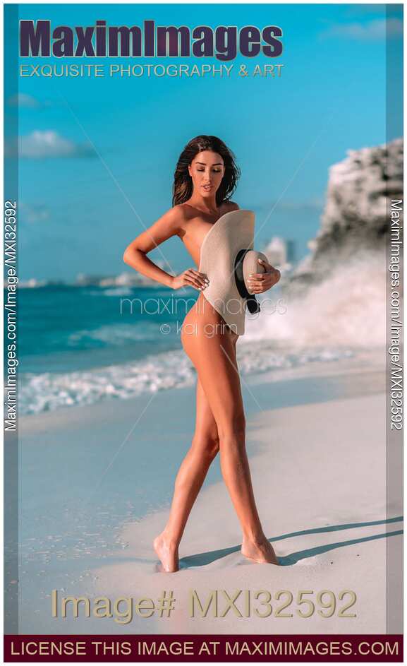 Sexy sun-tanned glamorous woman at a sandy beach covering her nude body with a sun hat Caribbean Sea Cancun